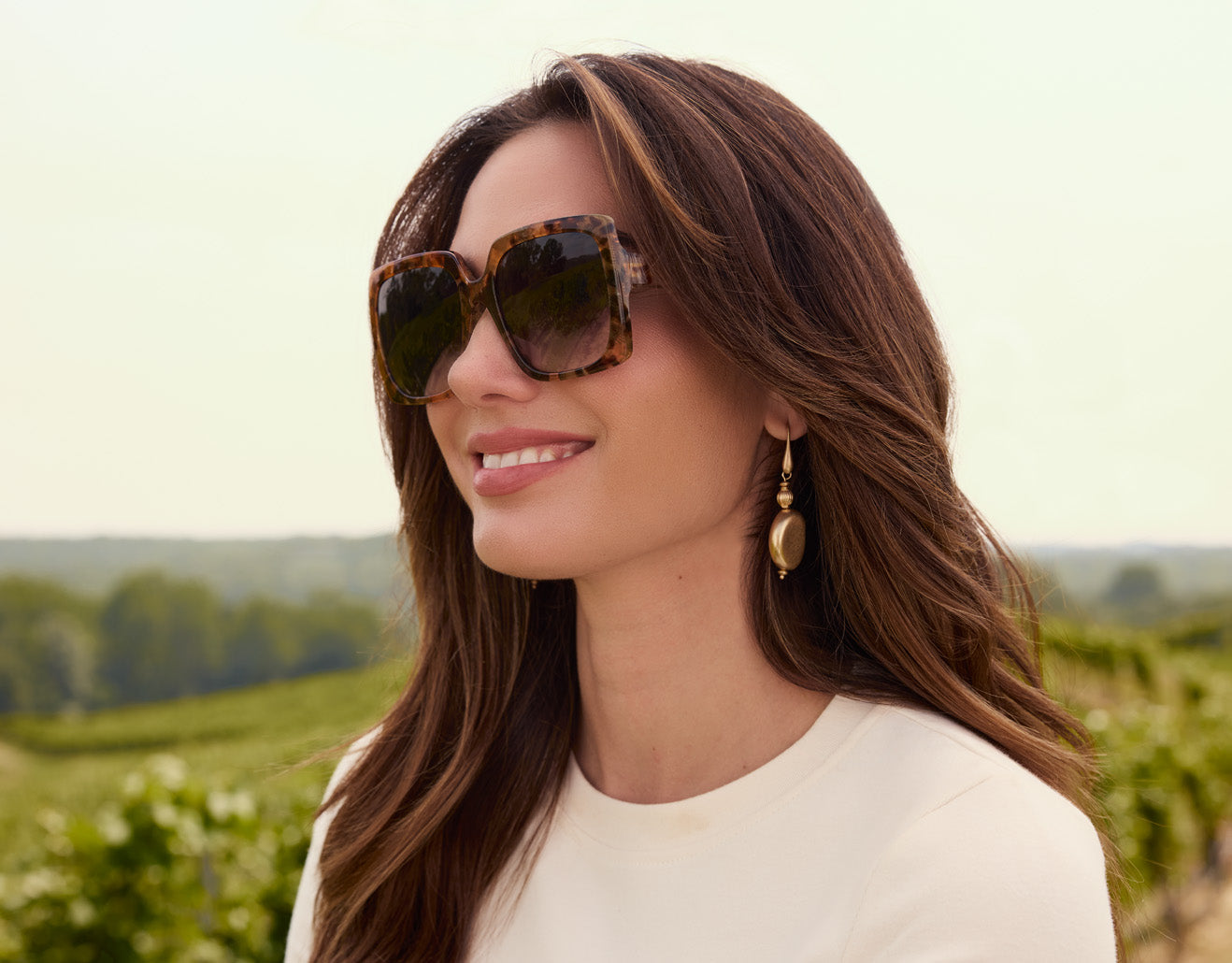 Model wearing Patricia Nash eyeglasses and earrings, showcasing vintage-inspired accessories in lifestyle setting