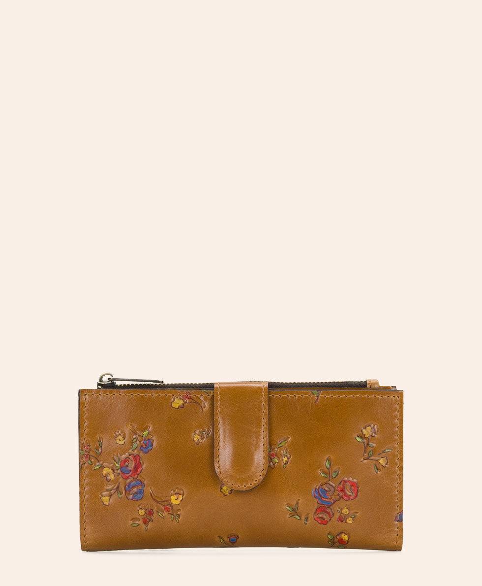 A tan leather zip-around pouch with a floral print in red, blue, and yellow, featuring a central tab closure, shown against a solid off-white background.