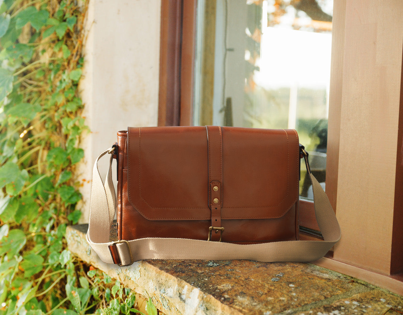 Men’s messenger bag by Patricia Nash, classic leather design displayed on neutral background